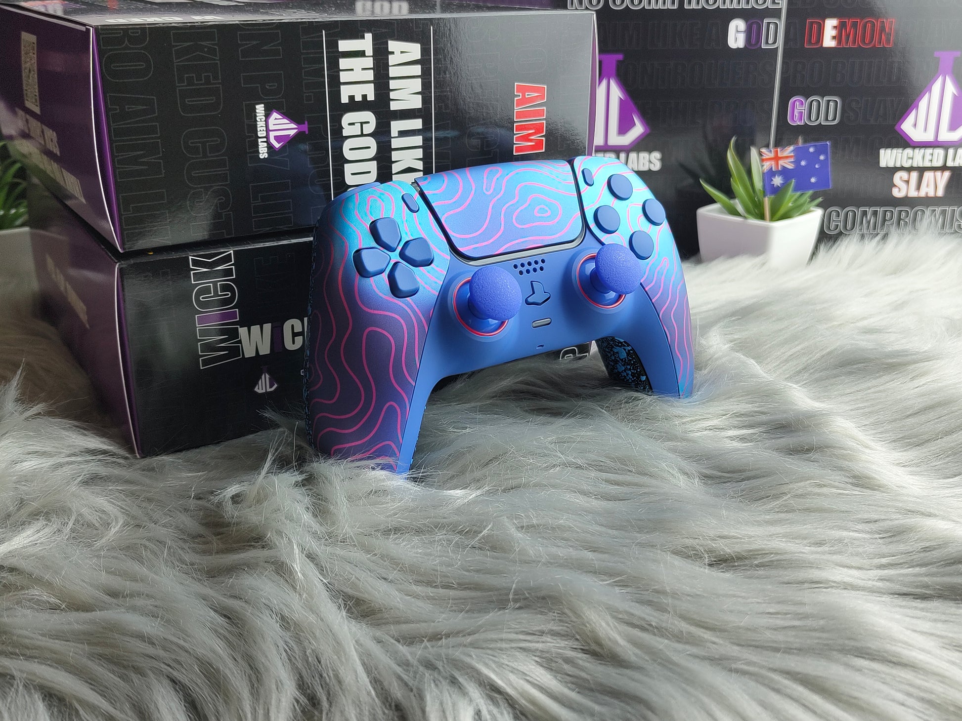 Blue gaming controller with purple accents on a fluffy white surface, with boxes in the background.
